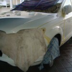 Before and after photographs of a damaged white, AUDI Quattro SUV that was repaired by Elite Paint & Body Shop in West Palm Beach, Florida.